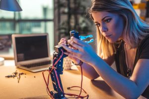 Young woman working in a robotics workshop.